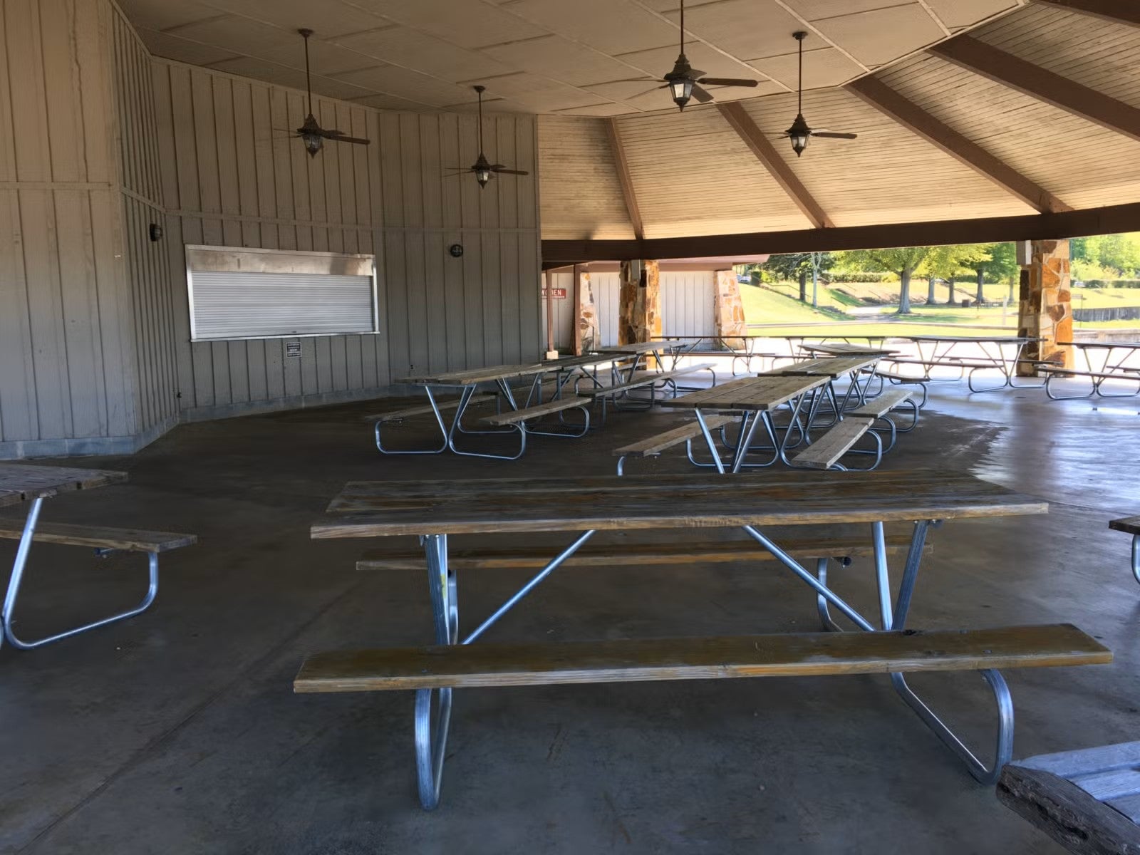 A picture of an outside, octagonal pavilion with picnic tables. 