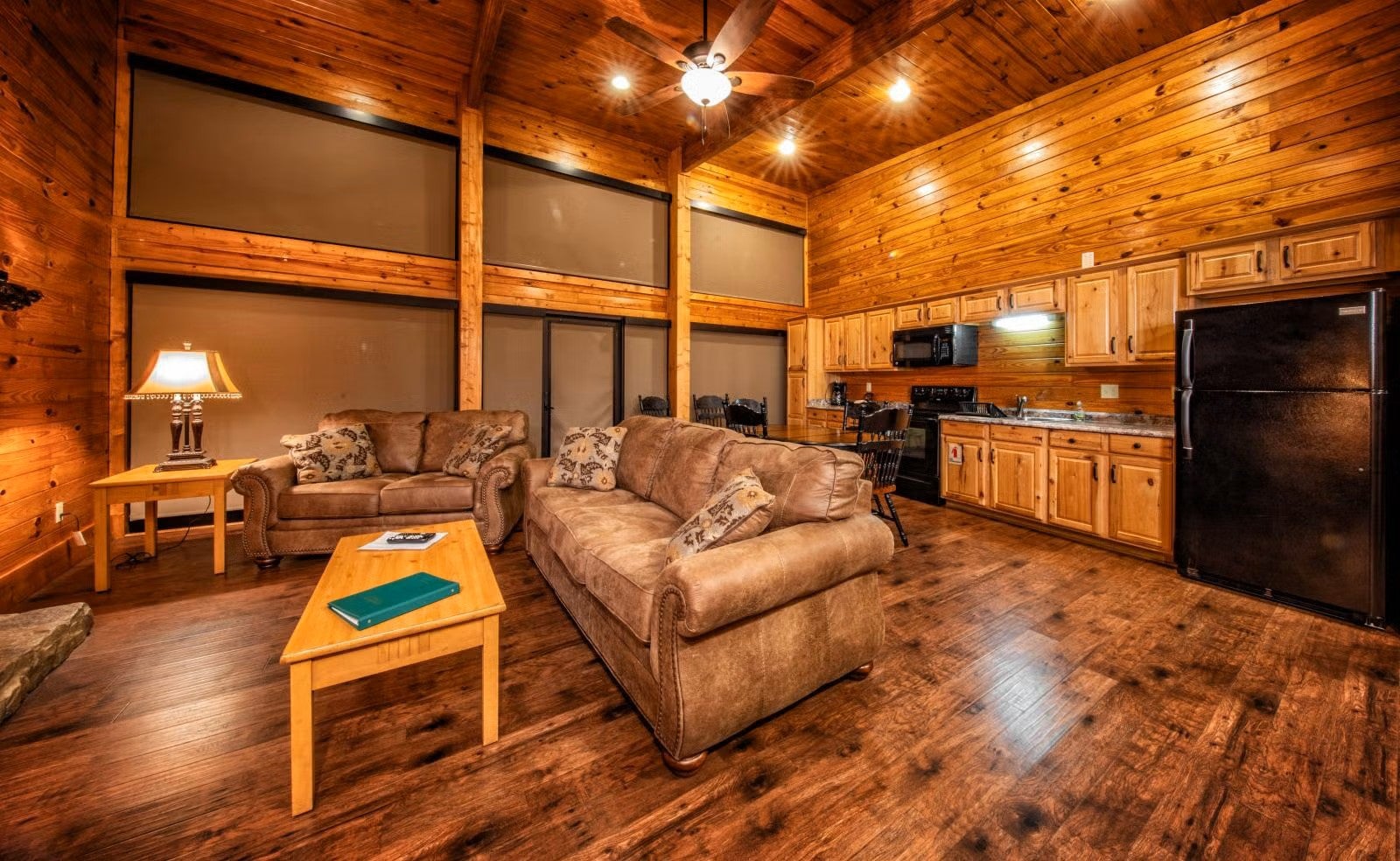 A picture of living from of the Executive Chalet showing a sofa, love seat and kitchen.