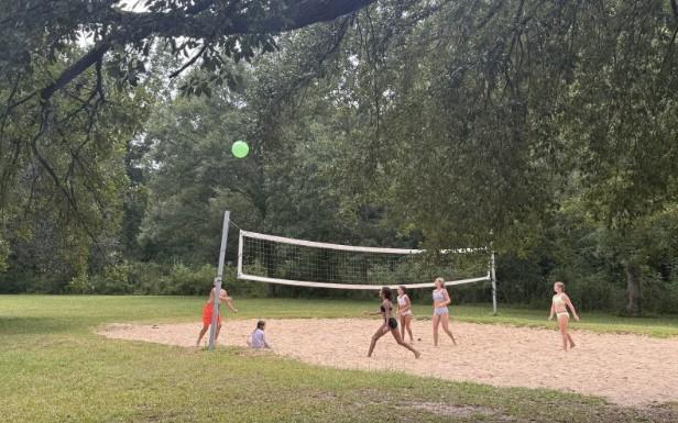 Kids playing volleyball outside.