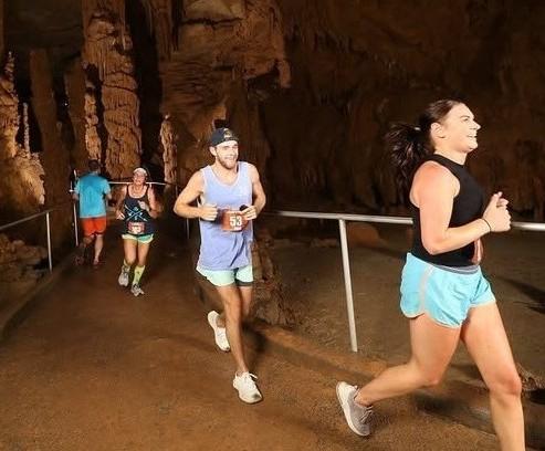 People running a race inside the cave at Cathedral Caverns State Park .